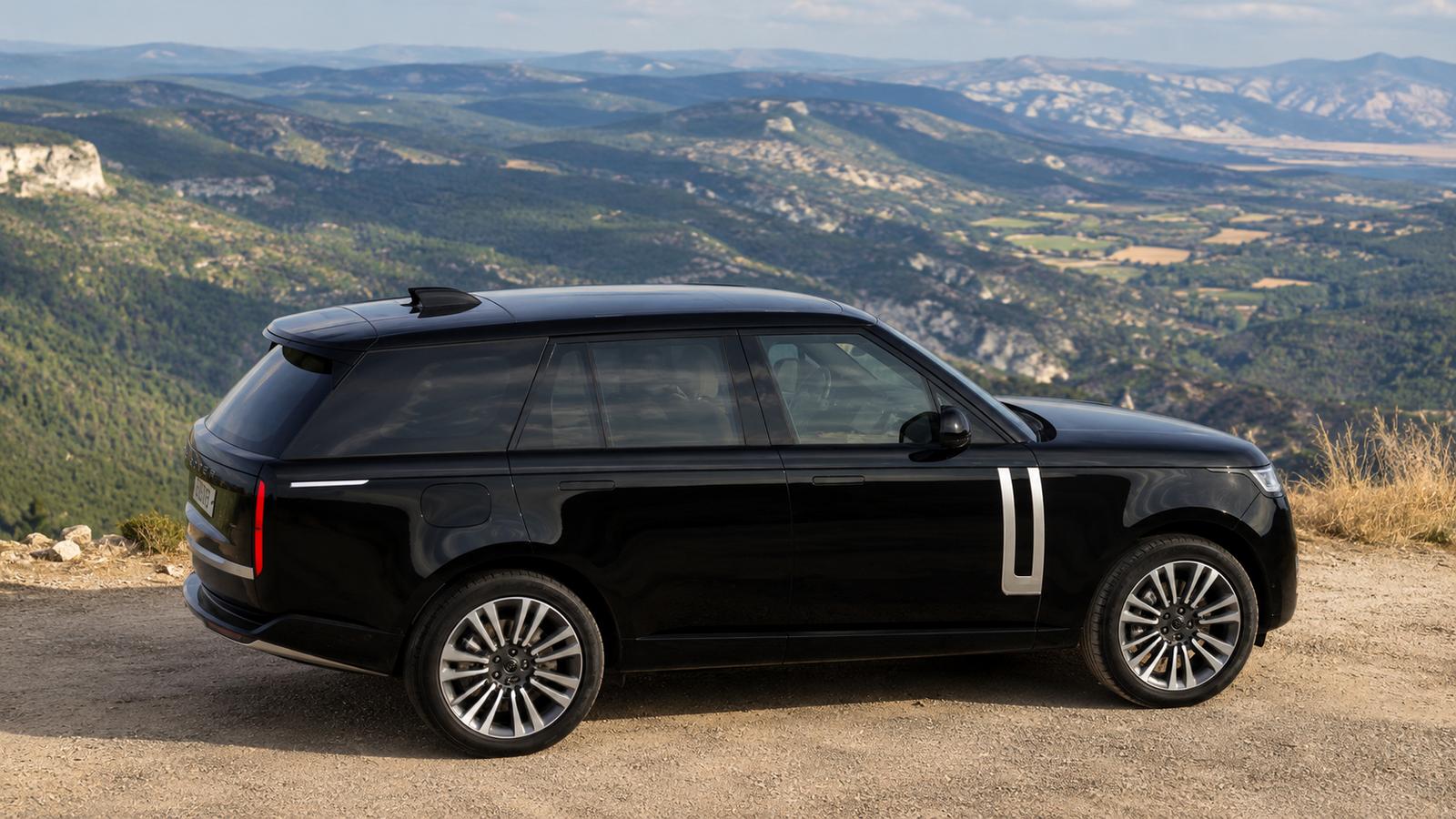 Ein schwarzer Range Rover Electric SUV auf einem Gebirgspass