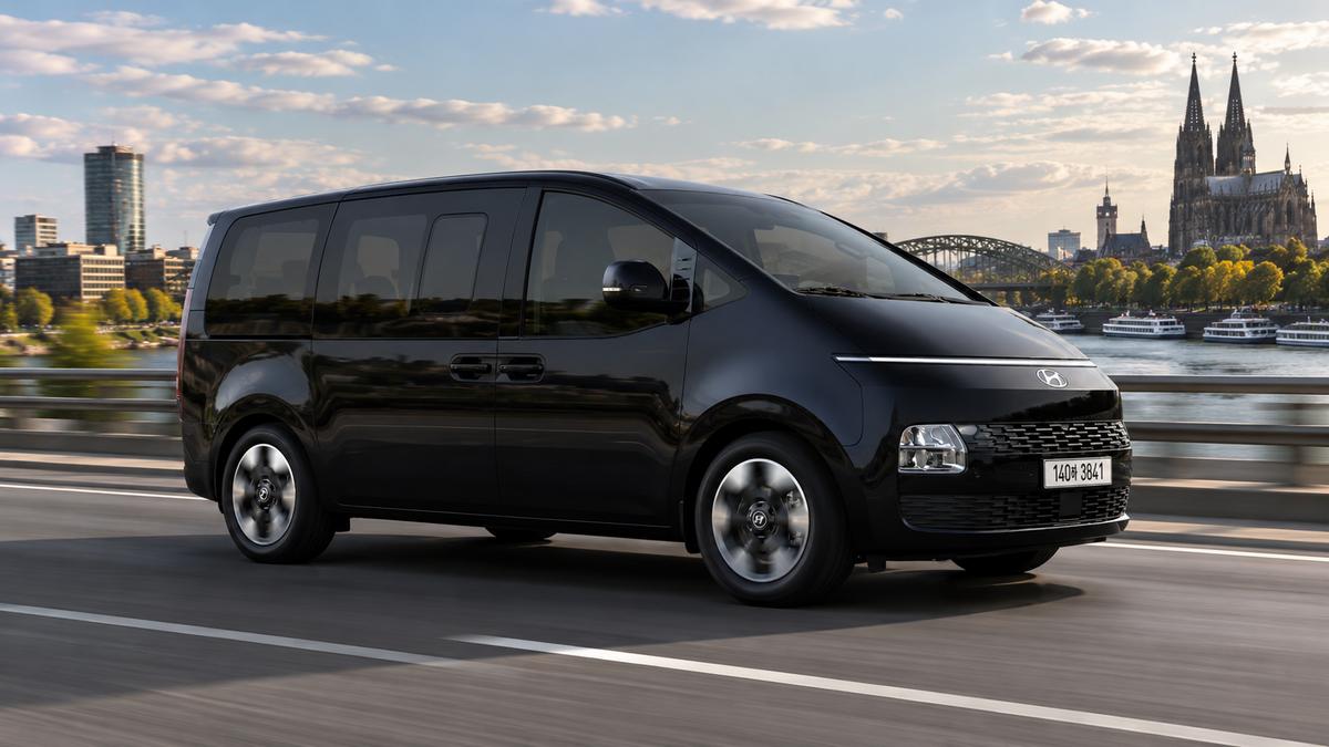 Ein schwarzer Hyundai Staria Elektro auf der Brücke nahe der Kathedrale.