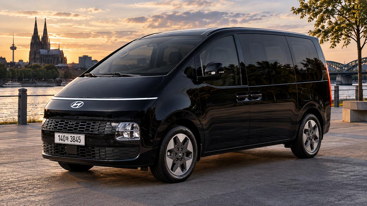 Schwarzer Hyundai Staria Elektro am Fluss bei Sonnenuntergang